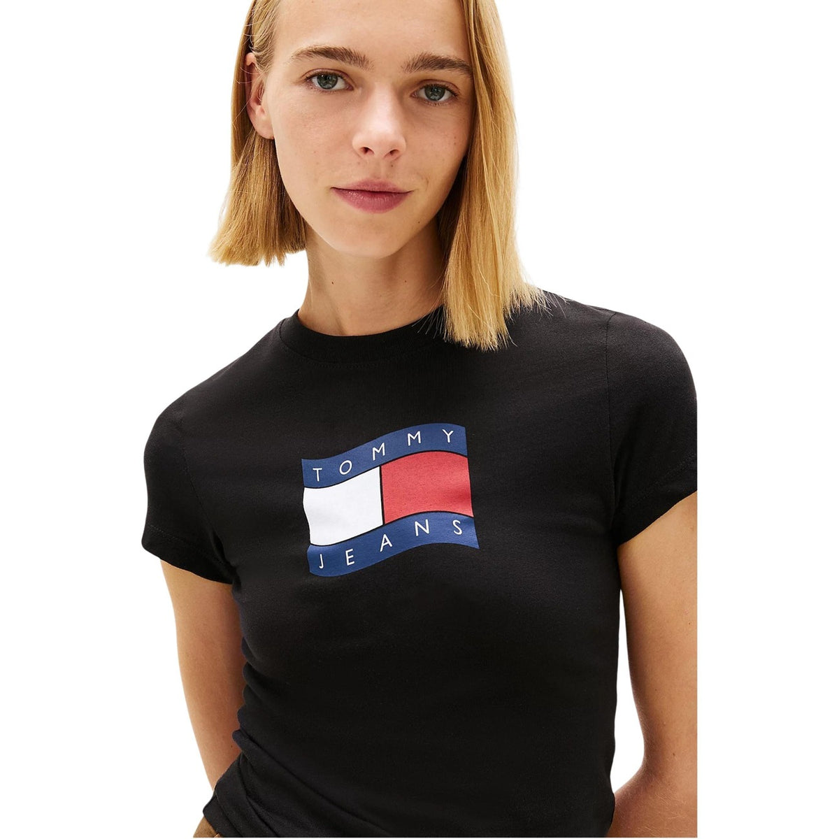 Tommy Jeans Slim Wavy Flag Tee; vestibilità aderente, puro cotone, logo grafico ondulato. La t-shirt iconica reinventata per lo streetwear moderno. Colore nero. Vista frontale