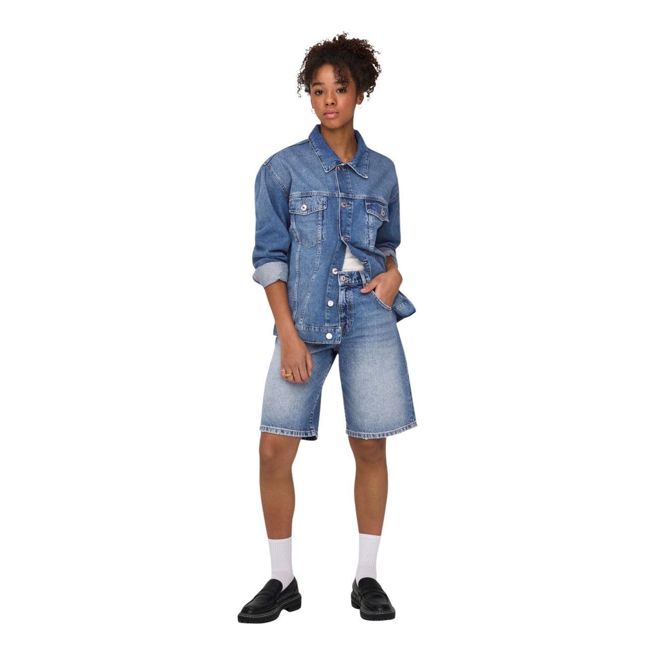 Bermuda Jeans Baggy Fit; 100% cotone naturale. Chiusura a bottoni, vita media, cinque tasche. Shorts ampi, traspiranti e ultra-comodi per la stagione PE26. Vista frontale figura intera 
