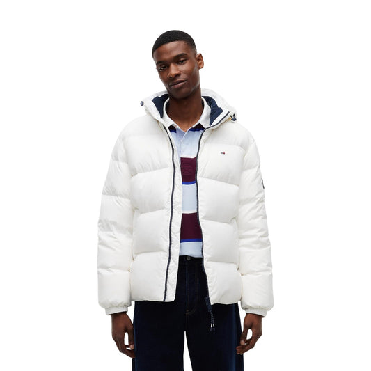 Piumino bianco uomo Tommy Jeans DM0DM19786YBL. Giambotto imbottito in piuma d'anatra relaxed fit oversize con cappuccio, zip integrale e logo Tommy ricamato.