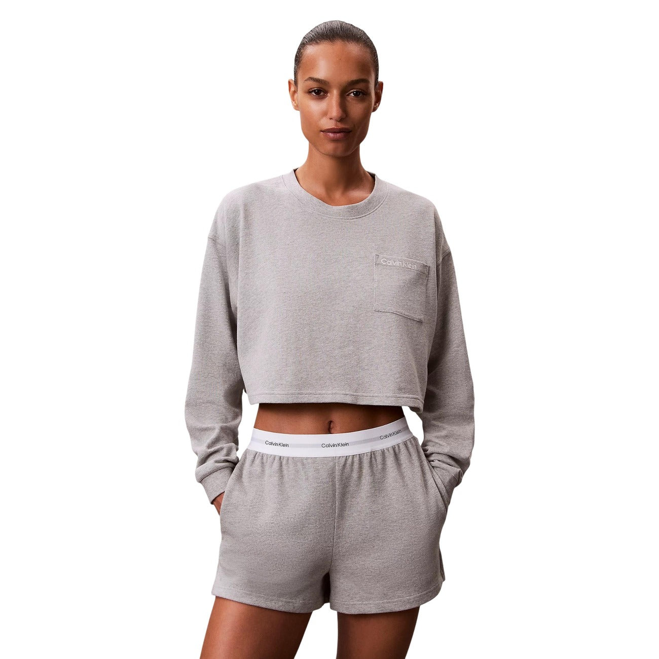 Pantaloncini pigiama Calvin Klein donna grigi. Shorts da notte e loungewear in morbido jersey di cotone a tinta unita con tasche laterali e spacco sull'orlo, caratterizzati dalla classica fascia elastica logata in vita, stile sportivo e minimalista.