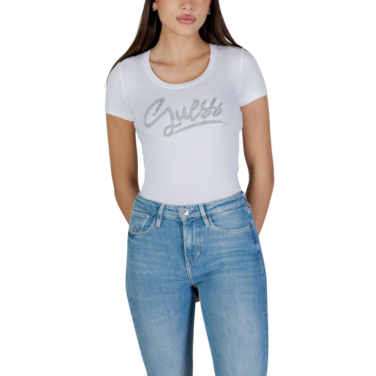 T-shirt bianca a maniche corte da donna Guess SS CN GUESS SCRIPT TEE W6RI24 J1314 Realizzata in morbido jersey di cotone elasticizzato (95% cotone, 5% elastam/lycra), offre una vestibilità aderente e confortevole, ideale per valorizzare la silhouette. Il logo Guess, impreziosito da dettagli luminosi sul petto
