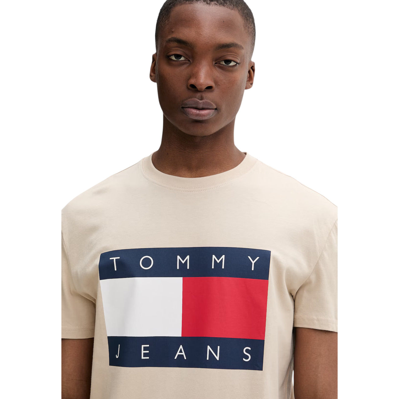 T-shirt Maniche Corte Beige Uomo Tommy Hilfiger Jeans; 100% cotone rigenerato ecosostenibile. Taglio dritto regular fit e scollo tondo girocollo. Stampa logo iconico sul petto, stile casual-luxury 4 stagioni. Vista frontale 
