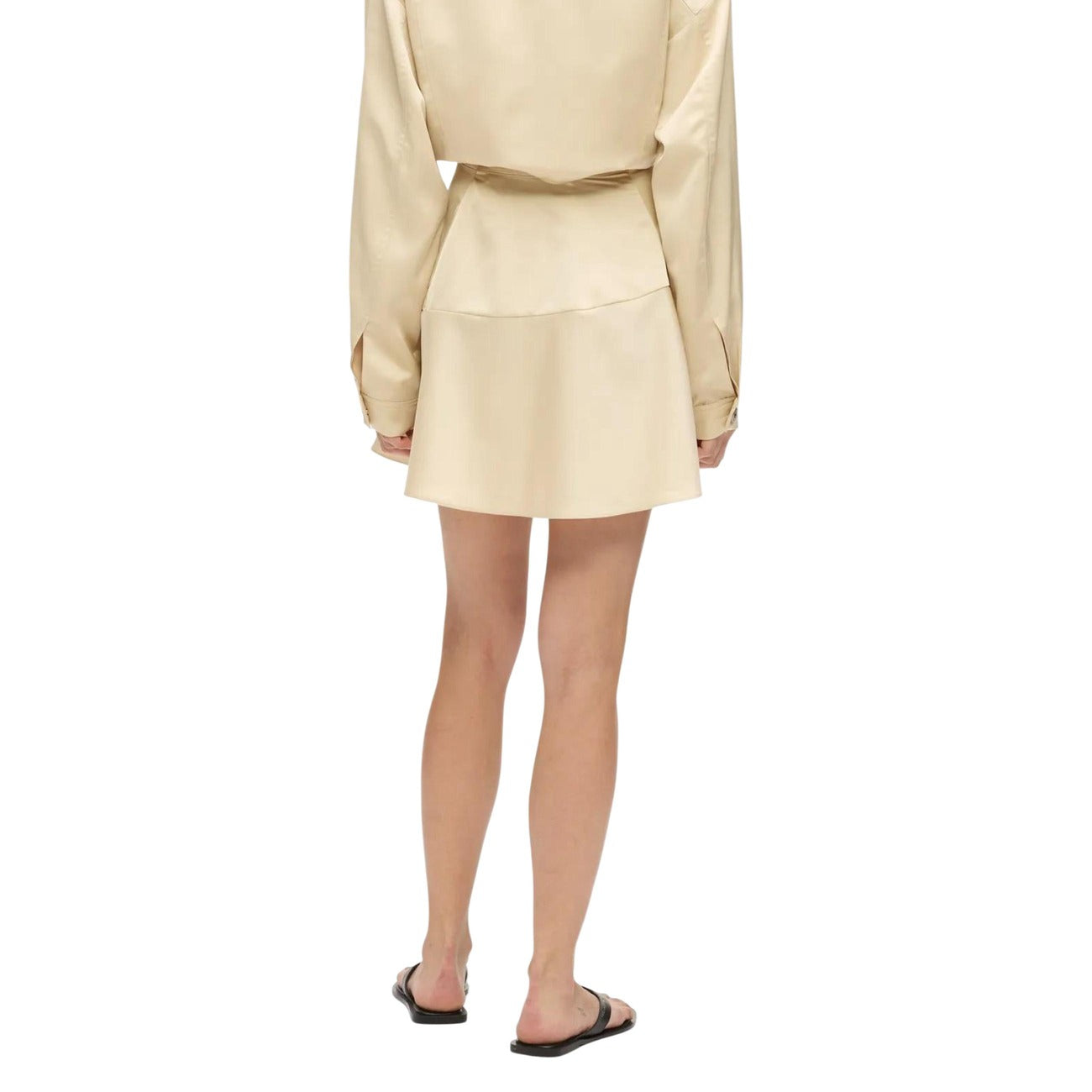Minigonna Raso Trapezio; 100% Poliestere. Finitura iridescente, zip invisibile, logo ricamato. Gonna corta donna elegante e luminosa per la stagione PE26. Colore beige vista posteriore 