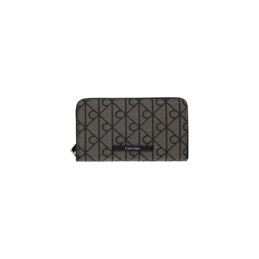 Portafoglio Porta Passaporto Donna Calvin Klein; Nero. Esterno in twill jacquard, interni in similpelle, chiusura con zip-around e blocco RFID antifrode. Scomparti interni per tessere, monete e biglietti aerei. Dimensioni: 19x11 cm. Vista frontale 