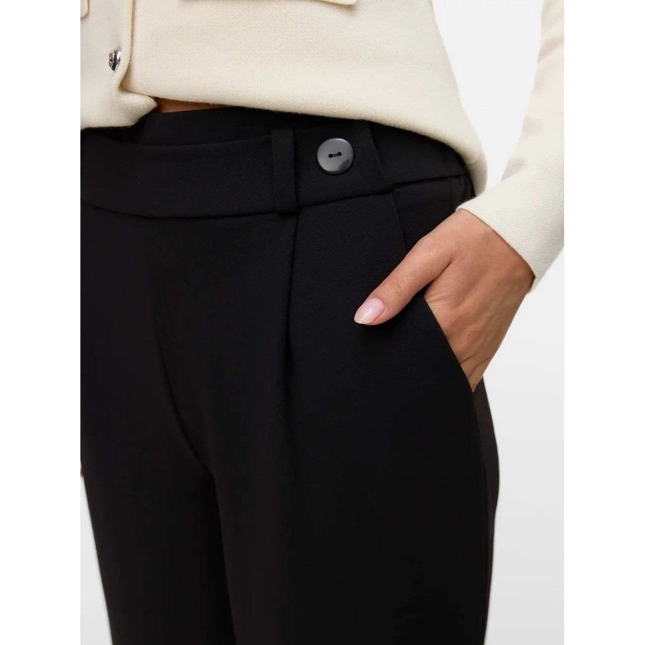 Pantaloni Donna Fantasia Nero Vero Moda Loose Fit; Taglio morbido e fluido in poliestere elasticizzato. Struttura senza chiusura con dettaglio bottone e tasche anteriori, stile casual primavera-estate. Vista Dettaglio bottone 