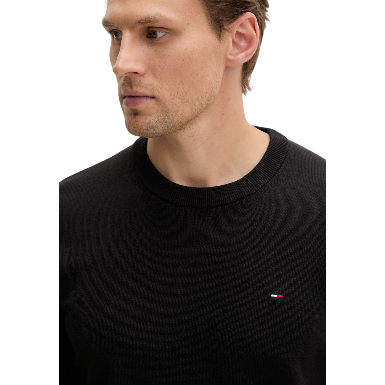 Maglione Girocollo Nero Uomo Tommy Hilfiger Jeans; 100% cotone rigenerato ecosostenibile. Tessuto a maglia fine con maniche lunghe e polsini a costine. Piccolo logo ricamato sul petto, modello pull-on mezza stagione.