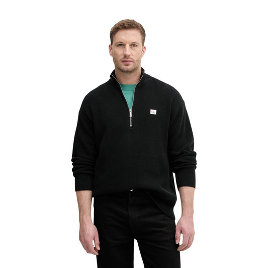 Maglione Nero con Zip Calvin Klein Jeans; 100% Cotone Pettinato. Lavorazione a nido d'ape, stemma monogramma, vestibilità comoda. Caldo, traspirante e versatile. Vista frontale 
