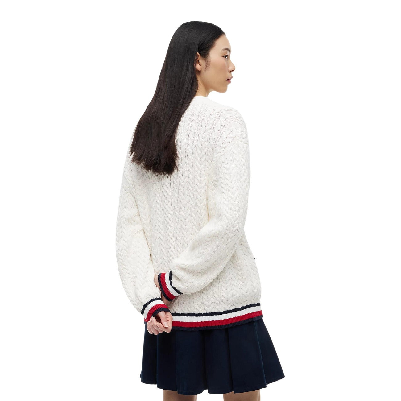 Cardigan Tommy Jeans donna bianco DW0DW22934. Maglione aperto in maglia intrecciata a trecce in 100% cotone biologico, scollo a V con bottoni, vestibilità oversize con stemma logo ricamato e finiture a righe stile college.