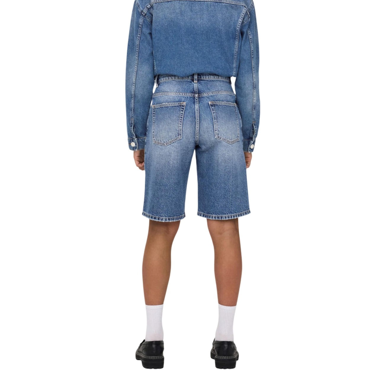 Bermuda Jeans Baggy Fit; 100% cotone naturale. Chiusura a bottoni, vita media, cinque tasche. Shorts ampi, traspiranti e ultra-comodi per la stagione PE26. Vista posteriore 