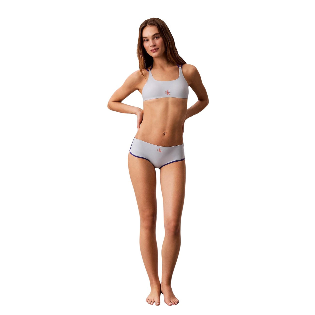 Bralette Bikini CK Jeans Azzurro; Doppie spalline a contrasto. Nylon riciclato e 33% elastam, asciugatura rapida, logo iconico. Design bicolore moderno, massimo comfort e coprenza. Vista figura intera 
