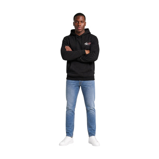 Felpa Nera Tommy Jeans; 100% Cotone Rigenerato. Cappuccio con coulisse, tasca a marsupio, logo ricamato. Morbida, sostenibile e versatile. Il must-have per la mezza stagione. Figura intera frontale 