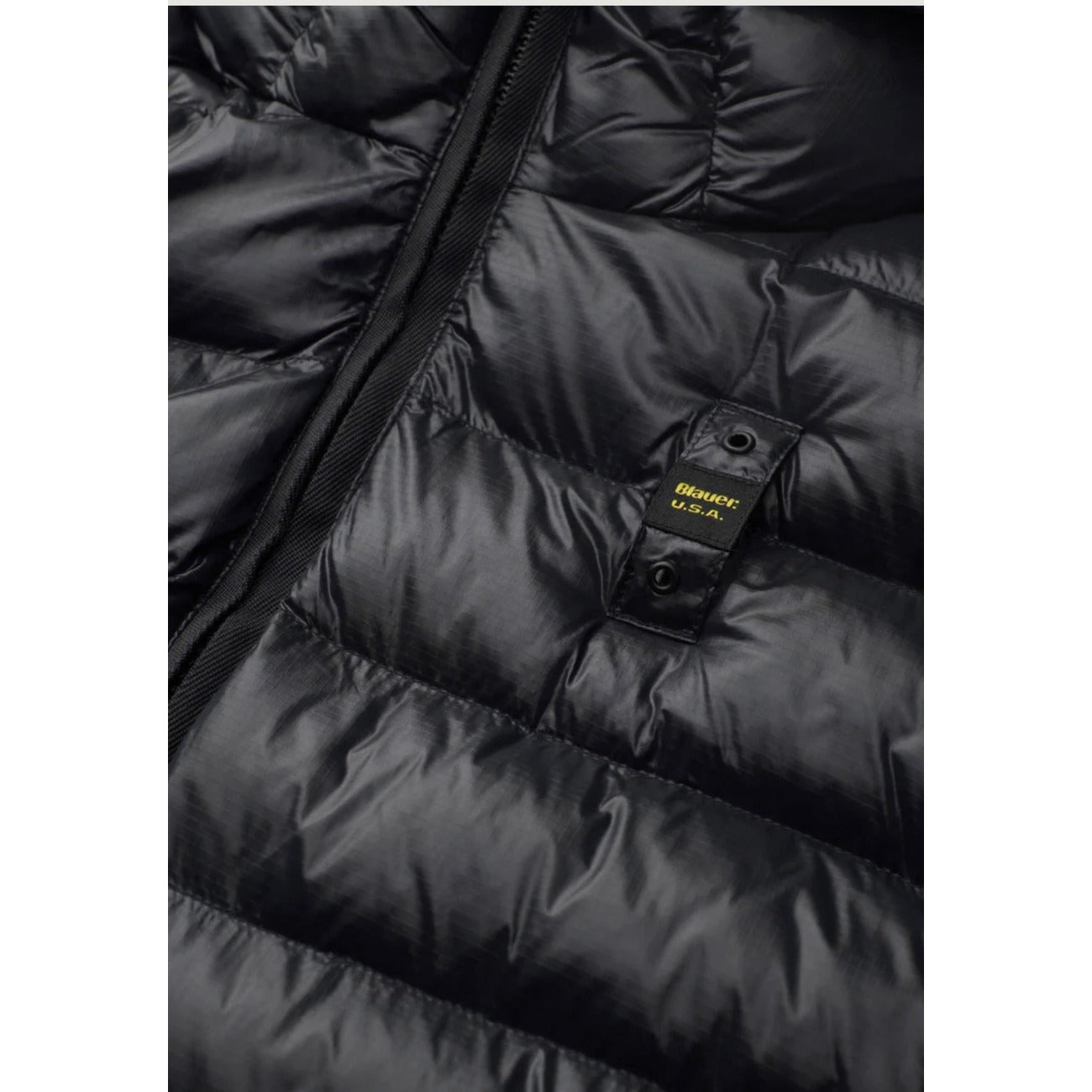 Piumino uomo Blauer nero Adams 26WBLUC02054. Giubbotto corto da uomo nero trapuntato con cappuccio fisso, chiusura zip, tasche laterali e logo Blauer su petto e manica, giacca invernale calda e casual.