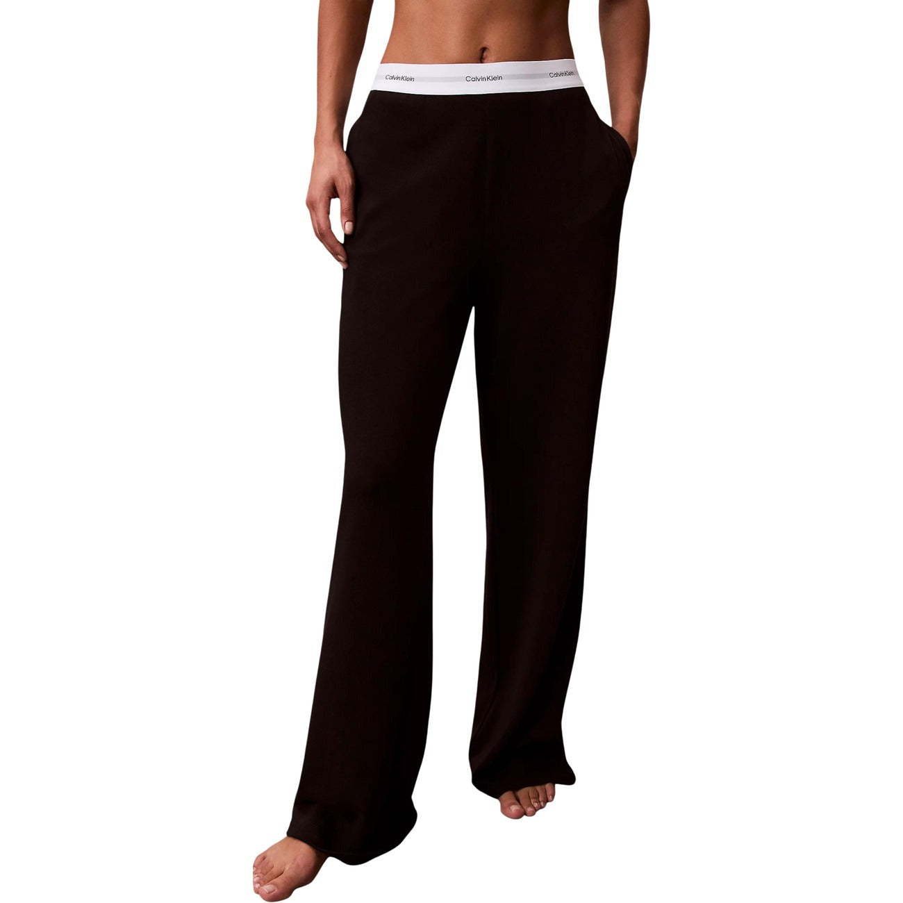 Pantaloni pigiama Calvin Klein donna neri modello LOGO JERSEY PANT. Pantalone lungo da notte e loungewear in maglia di cotone a coste tinta unita con tasche laterali e fondo con risvolto, dotato di fascia elastica logata in vita, stile casual sportivo e minimale.