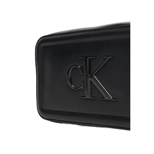 Calvin Klein Camera Bag Bold CK; borsa piccola nera in ecopelle nera con logo monogramma 3D. Pratica chiusura a cerniera e tracolla adattabile per un look urban sofisticato. Vista frontale Dettaglio logo