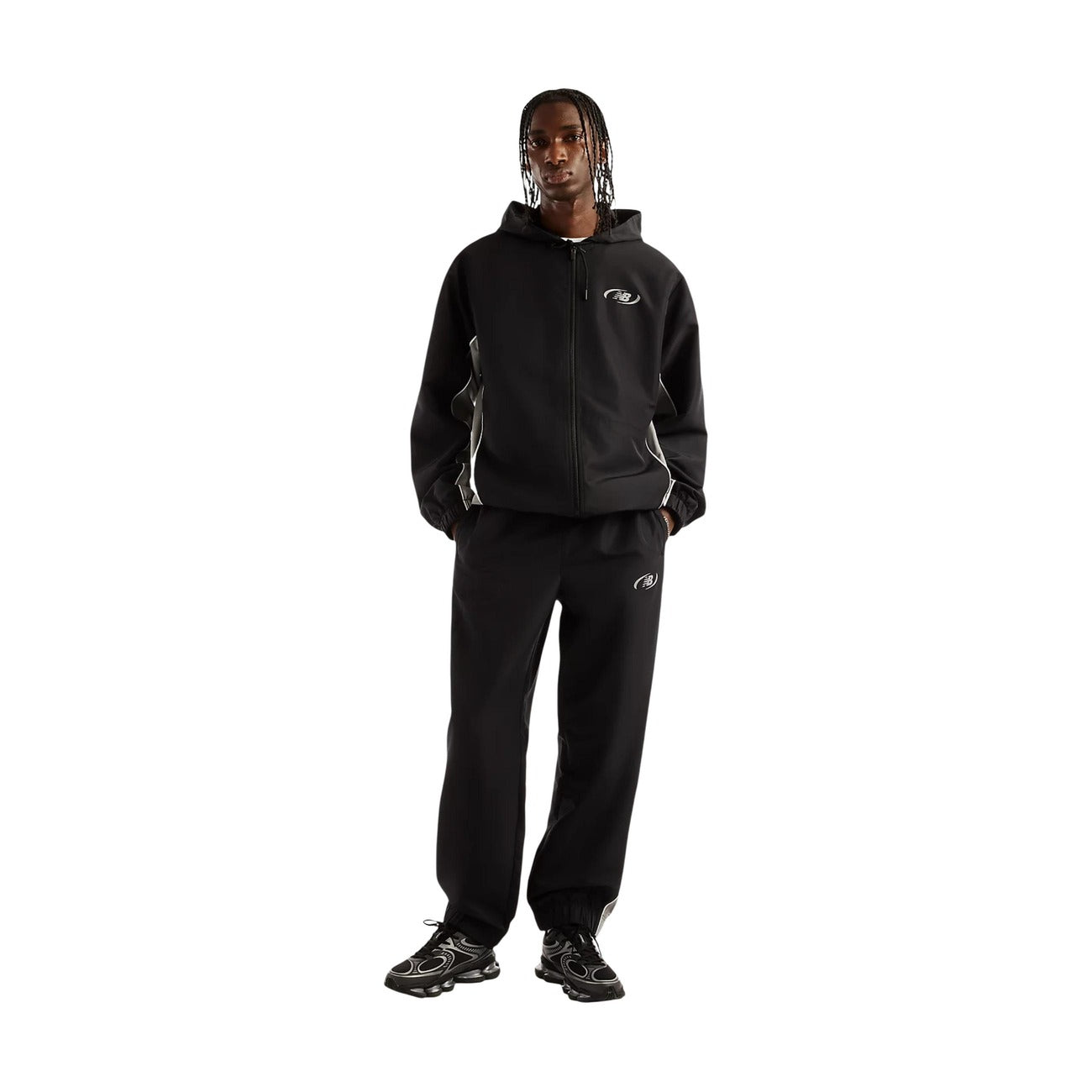 Pantaloni sportivi New Balance neri uomo MB62A8LTBK. Pantaloni tuta da uomo neri in poliestere con banda laterale a contrasto, fondo con elastico alla caviglia, tasche con cerniera e logo stampato, pantaloni casual da ginnastica 4 stagioni.