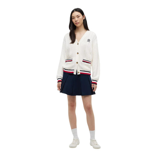 Cardigan Tommy Jeans donna bianco DW0DW22934. Maglione aperto in maglia intrecciata a trecce in 100% cotone biologico, scollo a V con bottoni, vestibilità oversize con stemma logo ricamato e finiture a righe stile college.