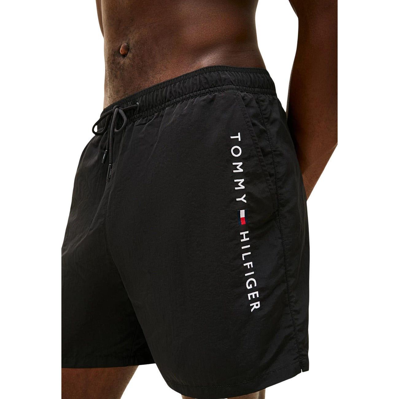 Costume Shorts Tommy Hilfiger; Nero. 100% Nylon. Lunghezza media (40,5 cm), chiusura con lacci, tasca laterale con zip. Dettagli iconici e logo ricamato, lavabile a 30°C. Dettaglio stampa 