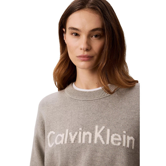 Maglione Girocollo Donna Grigio Calvin Klein Jeans; Maglia in puro cotone con maxi logo frontale a contrasto. Silhouette regolare con spalle scese, polsini a costine e stile casual. Dettaglio logo