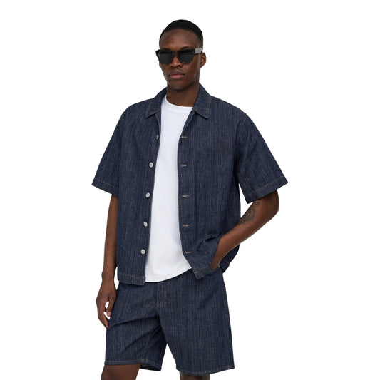 Camicia Manica Corta Only & Sons; Blu Effetto Denim. 100% Cotone leggero, Relaxed Fit, chiusura a bottoni. Cuciture a contrasto, stile casual contemporaneo, traspirabilità superiore. Vista frontale 