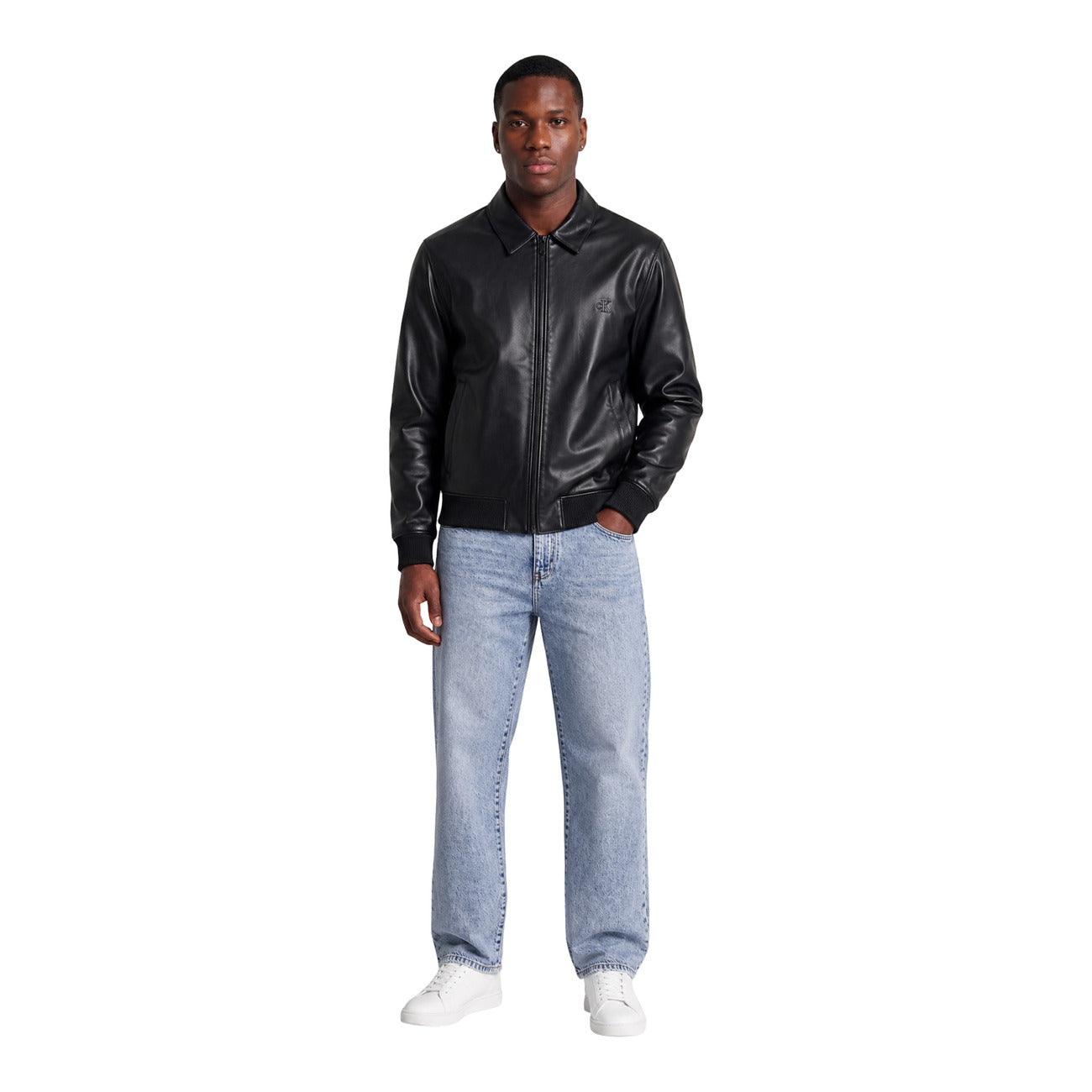 Giacca Leggera Nera Uomo Calvin Klein Jeans; Tessuto 100% poliestere riciclato con colletto classico e chiusura a zip. Polsini e fondo elastici con logo CK tono su tono sul petto, stile casual per mezza stagione. Figura intera frontale 