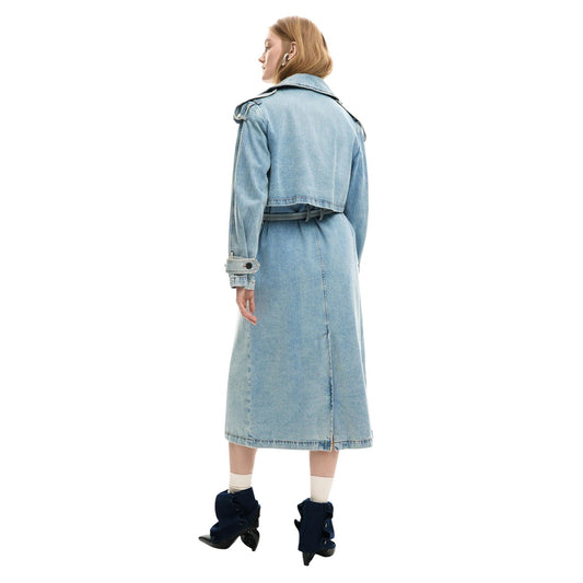 Giacca lunga stile trench in tessuto denim, con revers, chiusura con bottoni e cintura rimovibile. Indossata da modella figura intera vista posteriore 