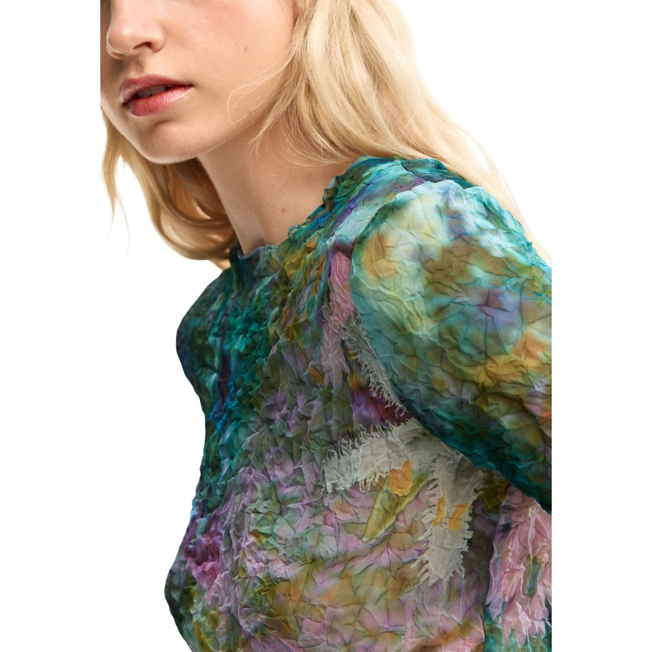 Blusa in tessuto testurizzato con stampa floreale digitale su tutto il capo. Presenta scollo rotondo e maniche lunghe con polsini aderenti. Taglio regular e design in colore blu minerale. Vista frontale laterale dettaglio scollo 