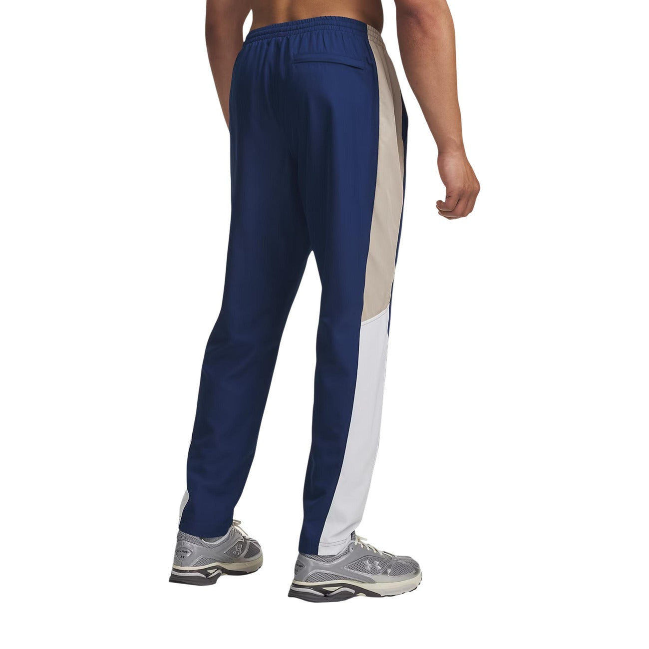 Pantaloni Under Armour uomo blu modello UA RIVAL WOVEN CB PANTS. Pantaloni lunghi da tute sportive e allenamento in poliestere con bande a contrasto colour block, vita elastica e tasche con cerniera, pantalone casual athleisure per la mezza stagione.