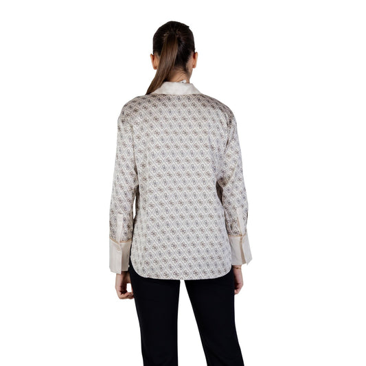 Realizzata con una composizione di 94% poliestere e 6% elastene, offre una vestibilità confortevole e leggermente elasticizzata che segue delicatamente le linee del corpo. Il design presenta un motivo geometrico all-over che dona carattere e originalità, mentre i polsini ampi e il colletto classico aggiungono un tocco di stile distintivo