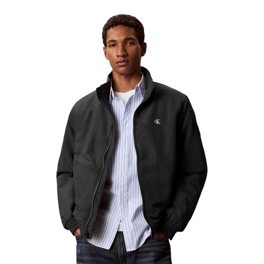 Giacca idrorepellente uomo Calvin Klein Jeans blu Dark Sapphire LV04RG500G. Giubbotto autunnale leggero in nylon con collo alla coreana, zip con tiralampo logo, orli elasticizzati e patch monogramma CK sulla manica, abbigliamento uomo mezza stagione.