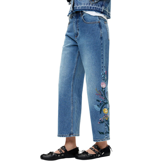 Jeans Desigual donna modello DENIM_BRIDGE. Pantaloni in denim blu lavato stile culotte a gamba larga con ricami a fiori colorati, realizzati in cotone sostenibile BCI leggermente elasticizzato, stile casual e boho-chic per la collezione autunno inverno.