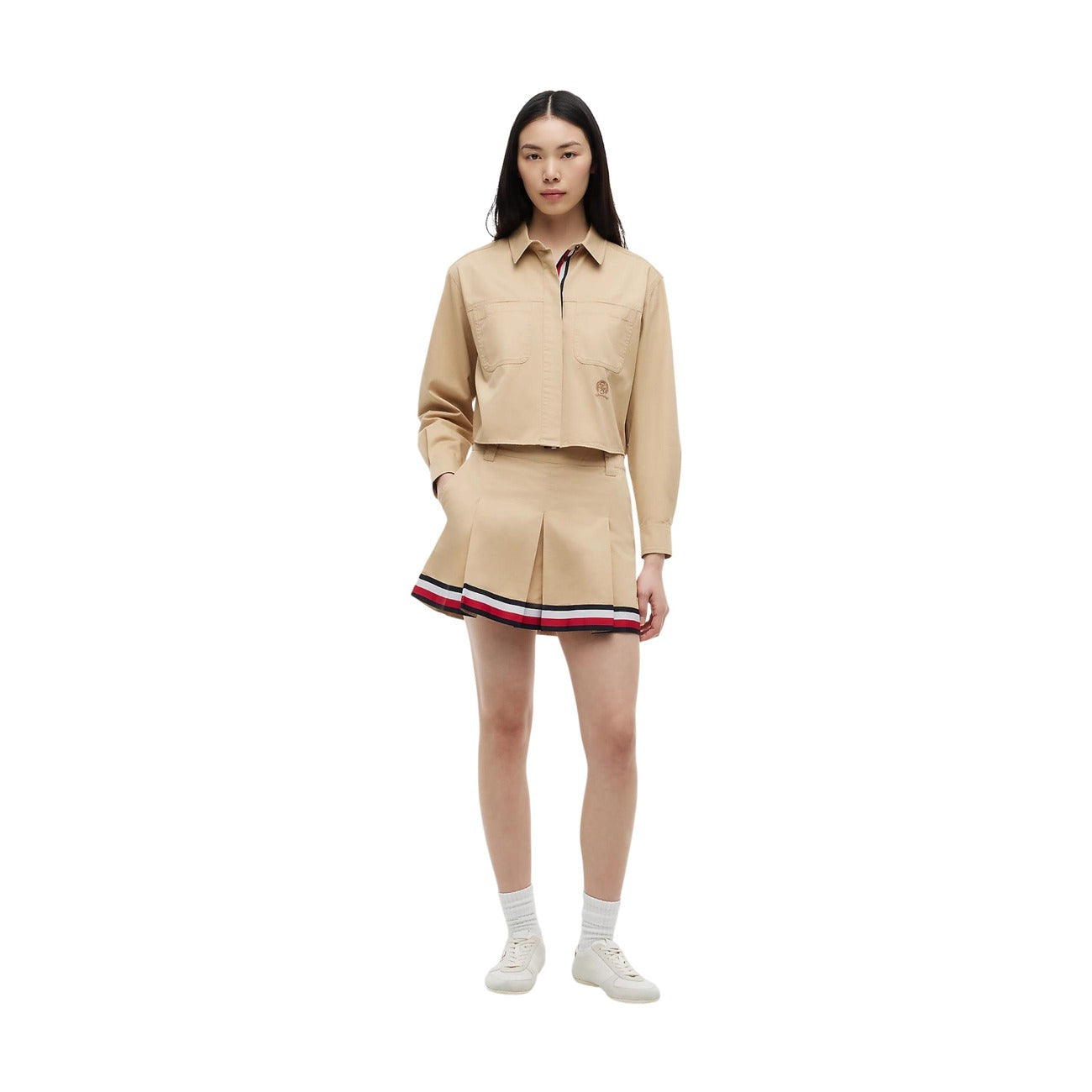 Gonna Tommy Jeans donna Gentle Gold DW0DW22969. Minigonna a pieghe in stile college in 100% cotone biologico, colore oro beige con tasche ad angolo e nastro riga Tommy sul fondo, abbigliamento donna autunno inverno.