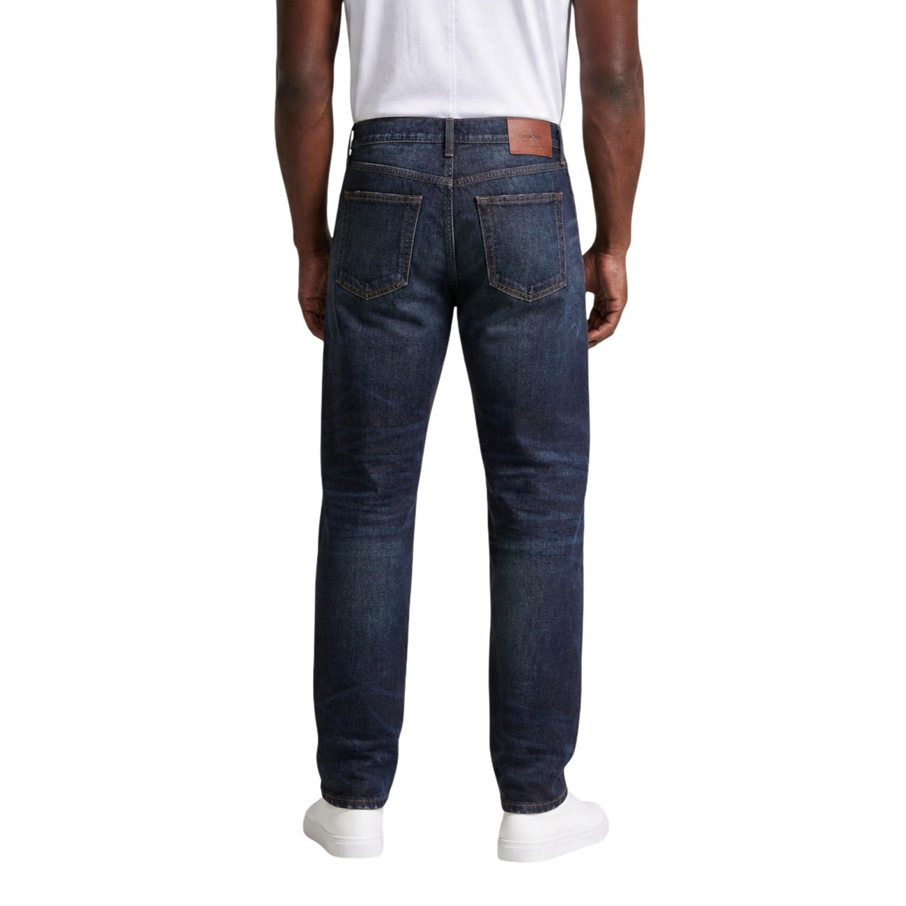 Jeans Regular/Loose Blu Calvin Klein; 100% Cotone. Taglio dritto, 5 tasche, vita media. Cuciture iconiche e logo applicato. Stile retro-contemporaneo, resistente e traspirante. Posteriore 