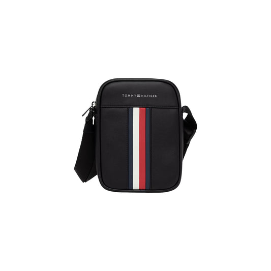 Borsa Reporter Uomo Tommy Hilfiger TH Metro; Nero. 100% Poliuretano liscio, chiusura superiore con zip, tracolla regolabile e nastro iconico frontale. Misure verticali e compatte (15x20 cm), capienza 1,85 litri. Frontale 