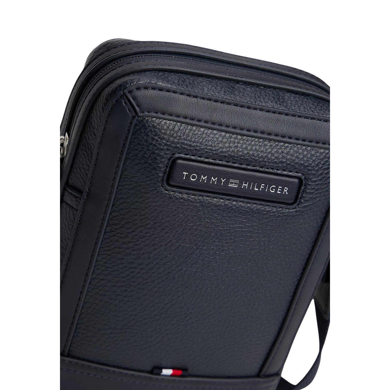 Tracolla uomo Tommy Hilfiger Mini Reporter; 100% Poliuretano. Logo applicato, tracolla regolabile, chiusura con zip. Borsa compatta uomo, versatile e moderna. Dettaglio logo 