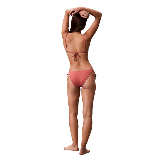 Slip Bikini CK Intense Power Rosa; Side Tie. Tessuto Lycra XTRA LIFE®, vita media, chiusura con lacci laterali. Interamente foderato, asciugatura rapida, vista posteriore figura intera 