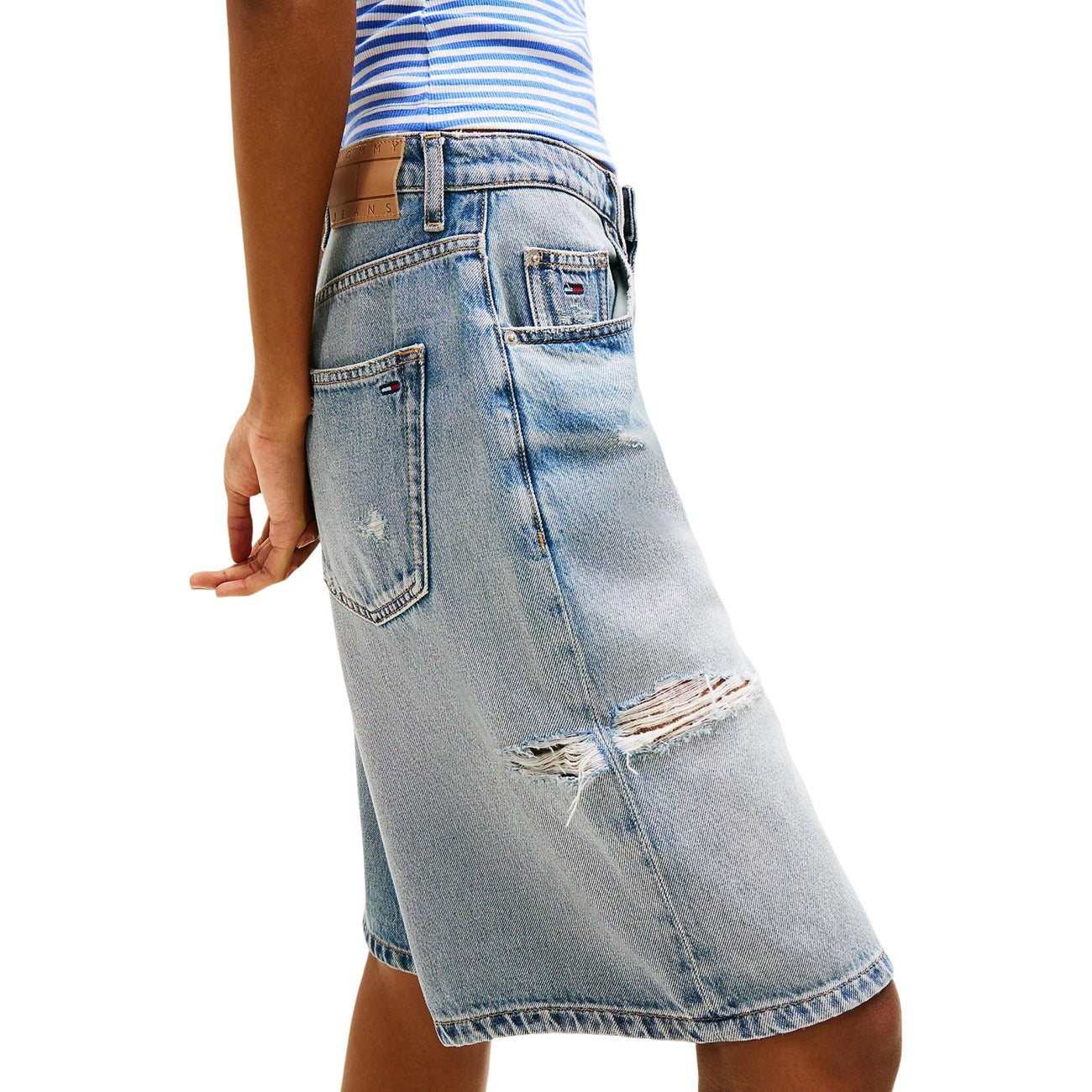Shorts Tommy Hilfiger Jeans Donna; Denim Blu Distressed. 71% Cotone, 29% Lyocell. Fit largo, strappi decorativi, logo ricamato. Tessuto leggero e traspirante per la stagione Primavera/Estate. Vista laterale 