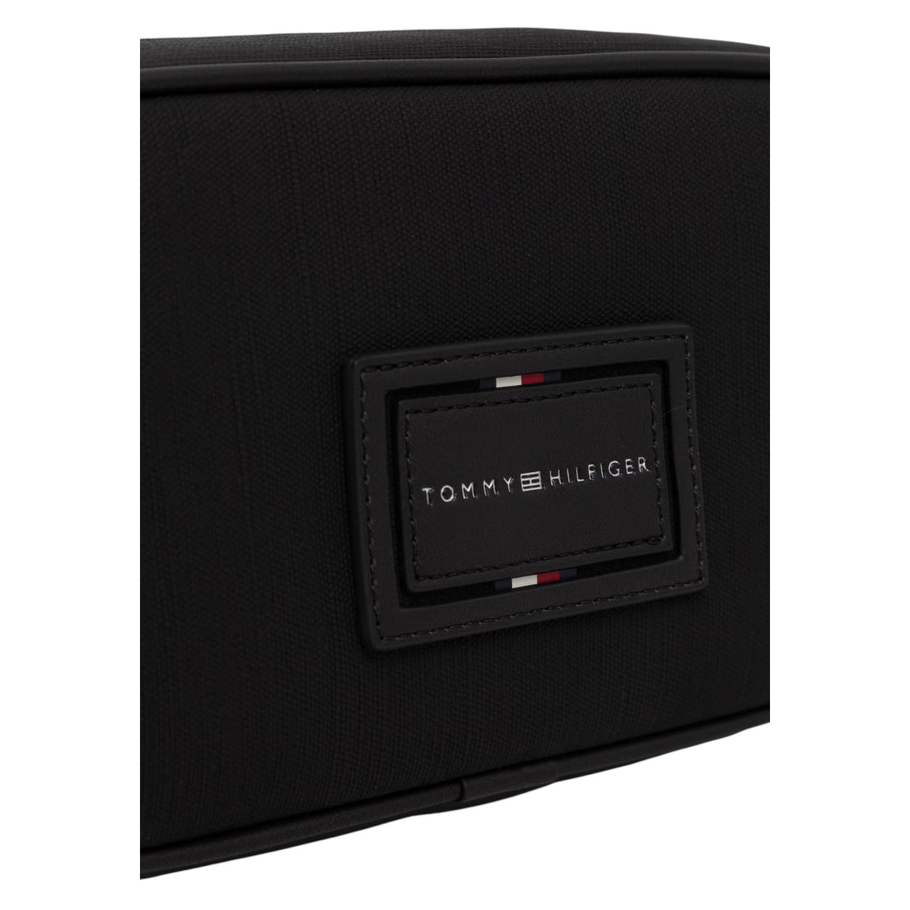 Pochette Beauty Uomo Tommy Hilfiger TH Foundation; Nero. 100% Poliuretano effetto pelle, chiusura con zip superiore, maniglia laterale per il trasporto e logo in rilievo. Misure compatte e capienti (22x12x8 cm). Dettaglio 