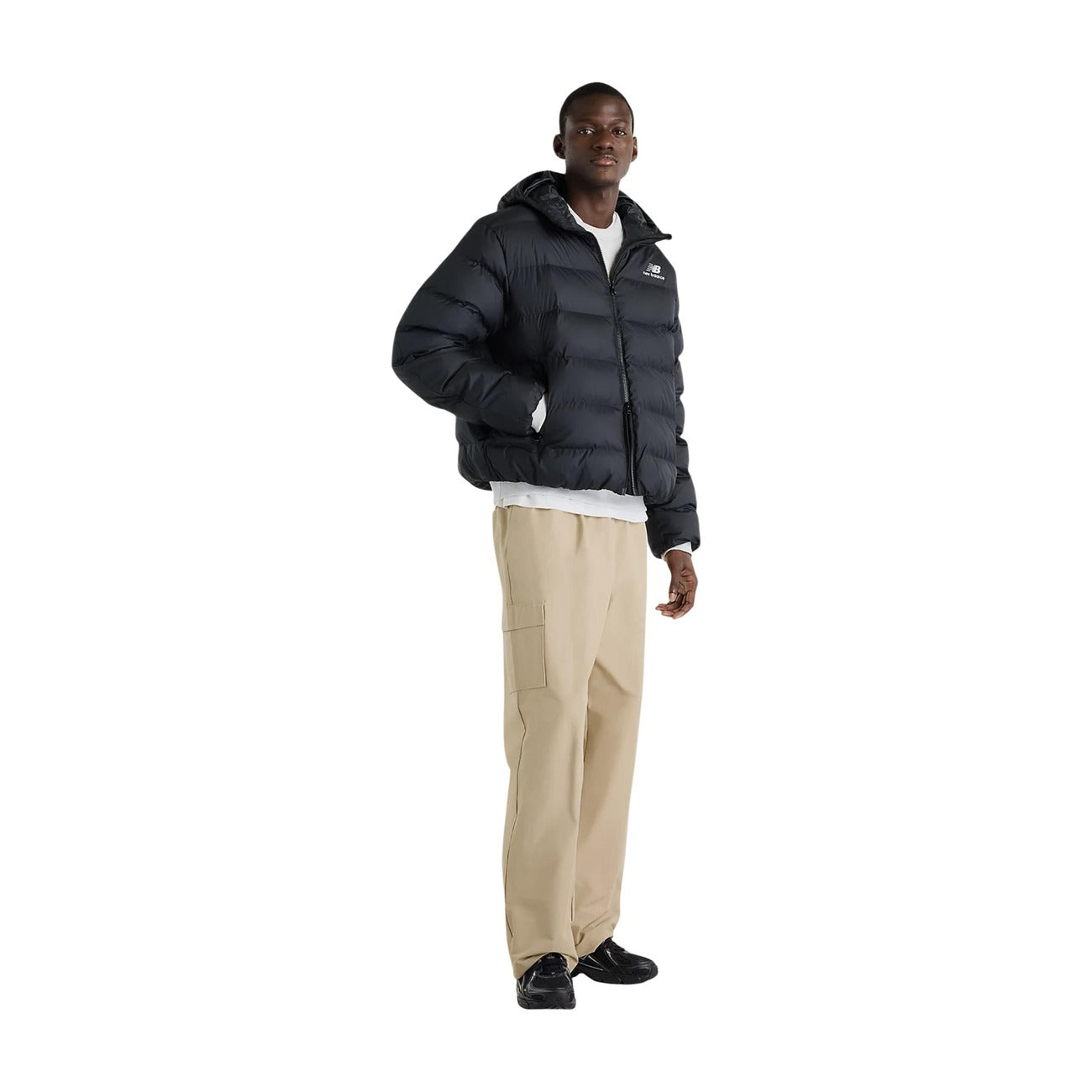 Piumino uomo New Balance nero MJ62G17OBK. Giacca invernale pesante da uomo nera in poliestere riciclato con ampia trapuntatura orizzontale, cappuccio regolabile, zip full zip e tasche con cerniera, giubbotto casual sportivo per il freddo.