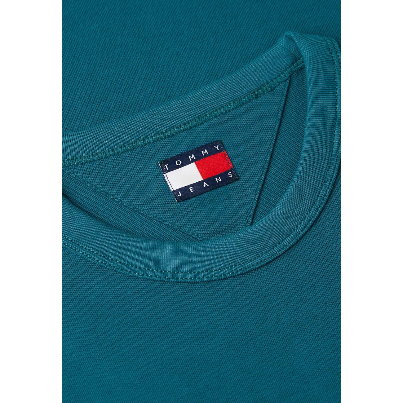 T-shirt Verde Tommy Jeans; Logo Badge Ricamato. 100% Cotone Rigenerato. Regular fit, girocollo classico, ecosostenibile. Il basic premium ideale per ogni outfit. Dettaglio 
