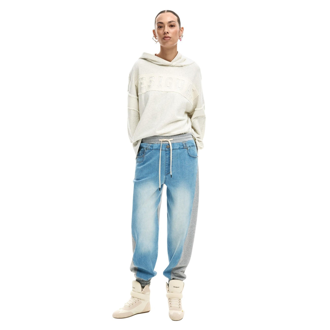 Pantaloni jogger in denim con elastico in vita, realizzati in due materiali a contrasto di colore. Indossato da modella 