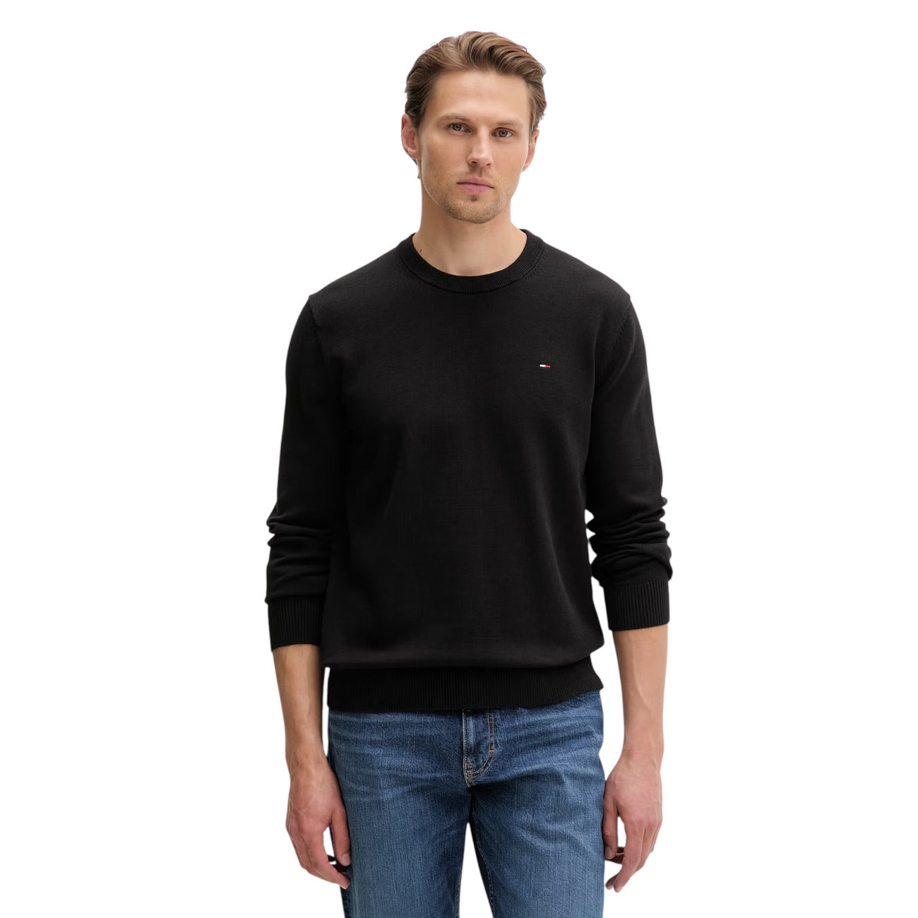 Maglione Girocollo Nero Uomo Tommy Hilfiger Jeans; 100% cotone rigenerato ecosostenibile. Tessuto a maglia fine con maniche lunghe e polsini a costine. Piccolo logo ricamato sul petto, modello pull-on mezza stagione. Vista frontale 