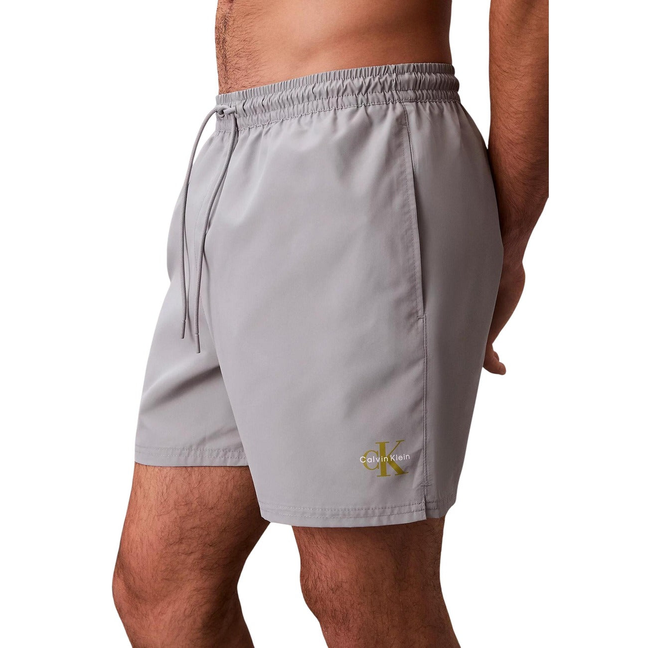 Boxer Mare CK Jeans Grigio; 100% Poliestere Impermeabile. Coulisse regolabile, tasche anteriori e posteriori con velcro, slip in rete. Lunghezza media, asciugatura ultra-rapida, stile moderno. Vista laterale 