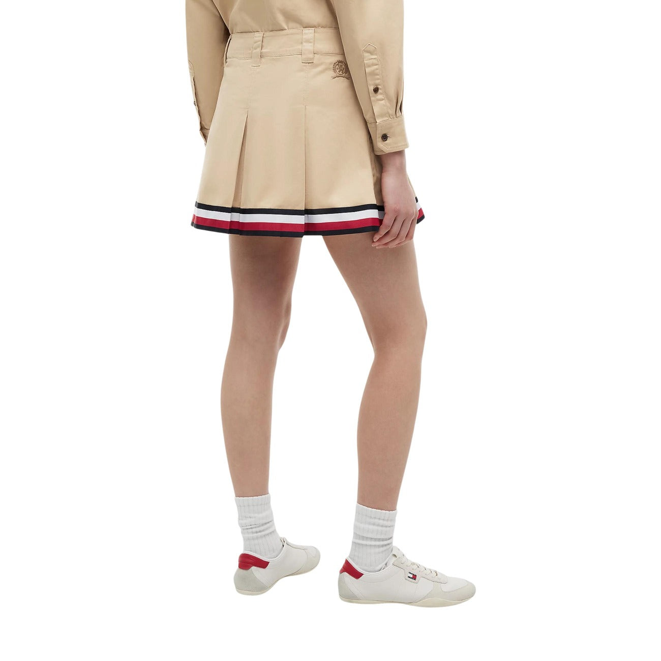 Gonna Tommy Jeans donna Gentle Gold DW0DW22969. Minigonna a pieghe in stile college in 100% cotone biologico, colore oro beige con tasche ad angolo e nastro riga Tommy sul fondo, abbigliamento donna autunno inverno.