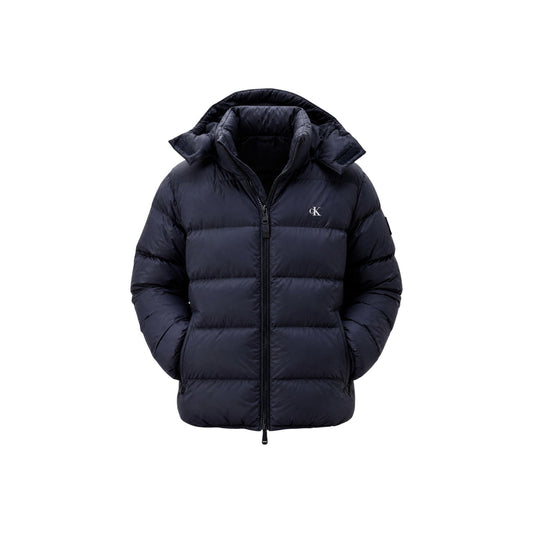 Giubbotto Calvin Klein Jeans uomo Dark Sapphire LV04RG515G. Piumino impermeabile blu scuro da uomo con cappuccio rimovibile, imbottitura vera piuma, doppia cerniera zip e dettaglio monogramma CK, giacca invernali da uomo.