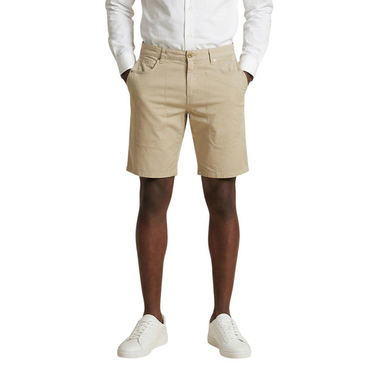 Bermuda Jeckerson Jayden Slim; 98% Cotone, 2% Elastam. Modello 5 tasche con toppe iconiche, tessuto stretch leggero. Short uomo raffinati e confortevoli, Made in Italy. Colore beige chiaro. Vista frontale indossato da modello 