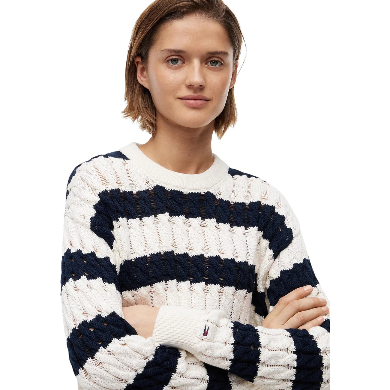 Maglione Tommy Jeans donna blu scuro DW0DW22926. Pullover in maglia intrecciata a trecce in cotone biologico, vestibilità ampia con girocollo e logo bandiera sulla manica, abbigliamento donna autunno inverno.