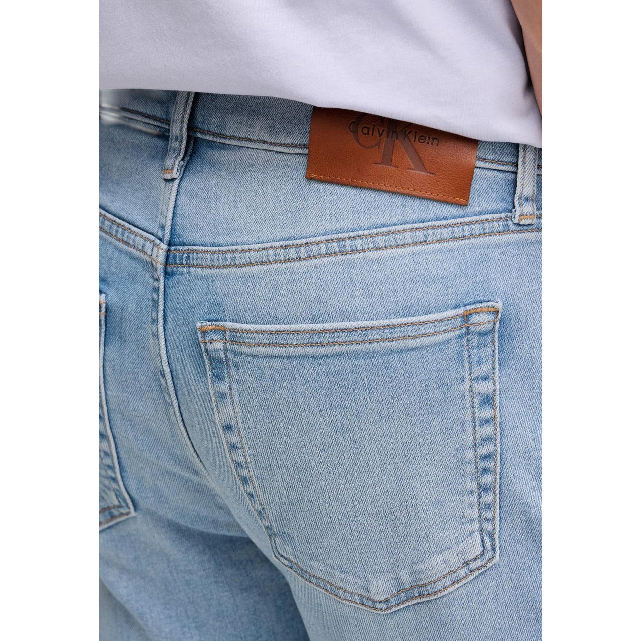 Jeans Slim Calvin Klein; Blu. 85% Cotone, 13% Poliestere Riciclato, 2% Elastan. Vita media, 5 tasche, chiusura con cerniera. Vestibilità asciutta e tessuto elasticizzato sostenibile Dettaglio 