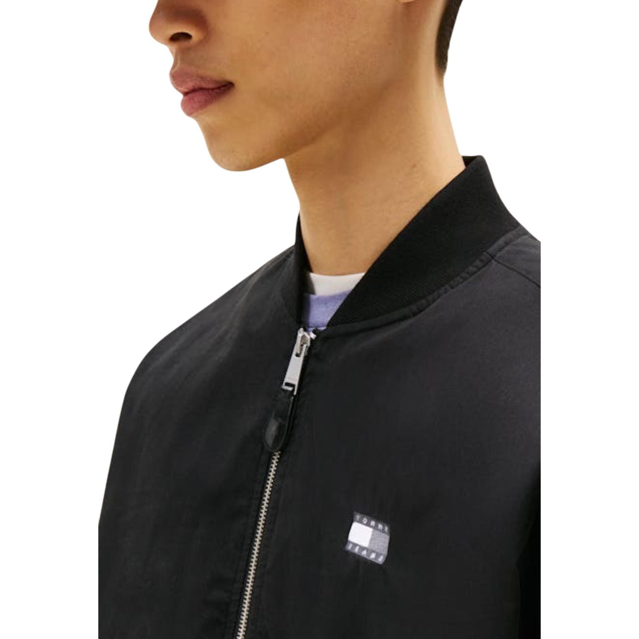 Bomber Tommy Jeans Nero; 85% Cotone Rigenerato. Chiusura a zip, taschino sulla manica, finiture a coste. Logo ricamato, tessuto resistente e sostenibile per la mezza stagione.