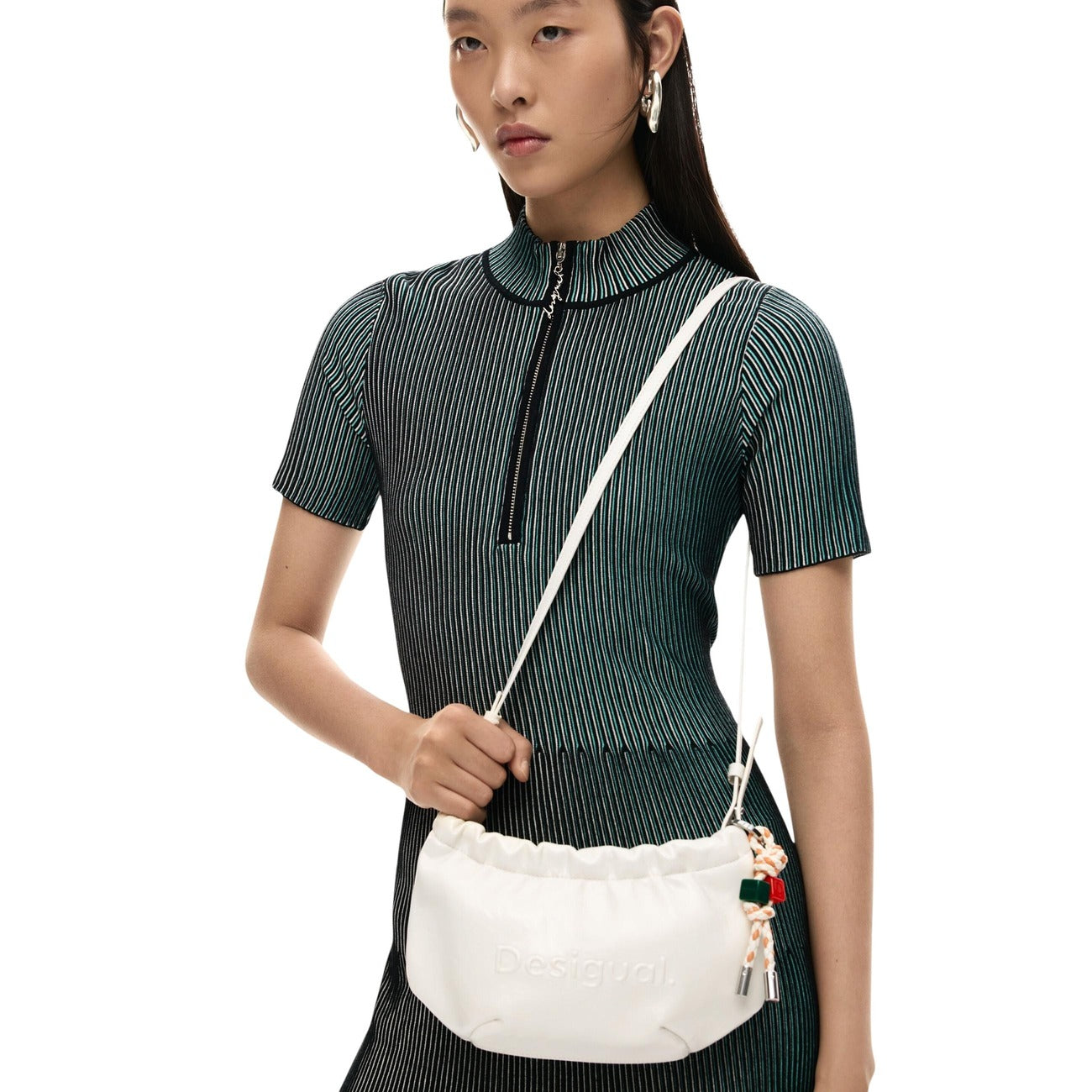 Portafoglio Bandoliera SS26; effetto pelle, logo inciso, tracolla extra-lunga (195 cm). Manico rimovibile, charm portacarte, tasca interna zip. Design Barcellona, versatile e contemporaneo. Indossata da modella 