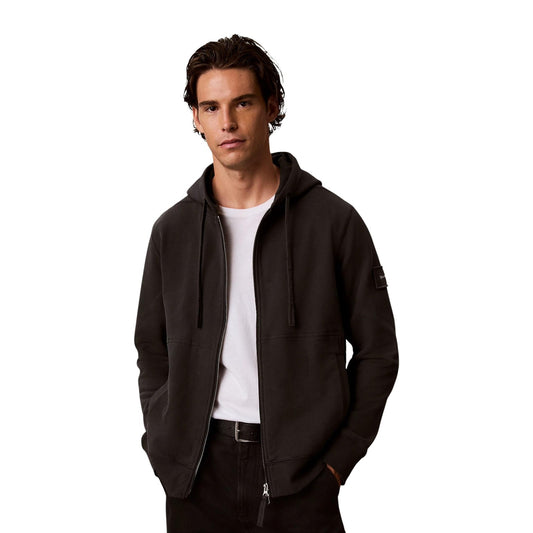 Felpa Calvin Klein Jeans uomo nera con zip LV04RJ202G. Felpa aperta con cappuccio in cotone effetto camoscio, cerniera doppio cursore, vestibilità rilassata e logo monogramma CK applicato sulla manica.